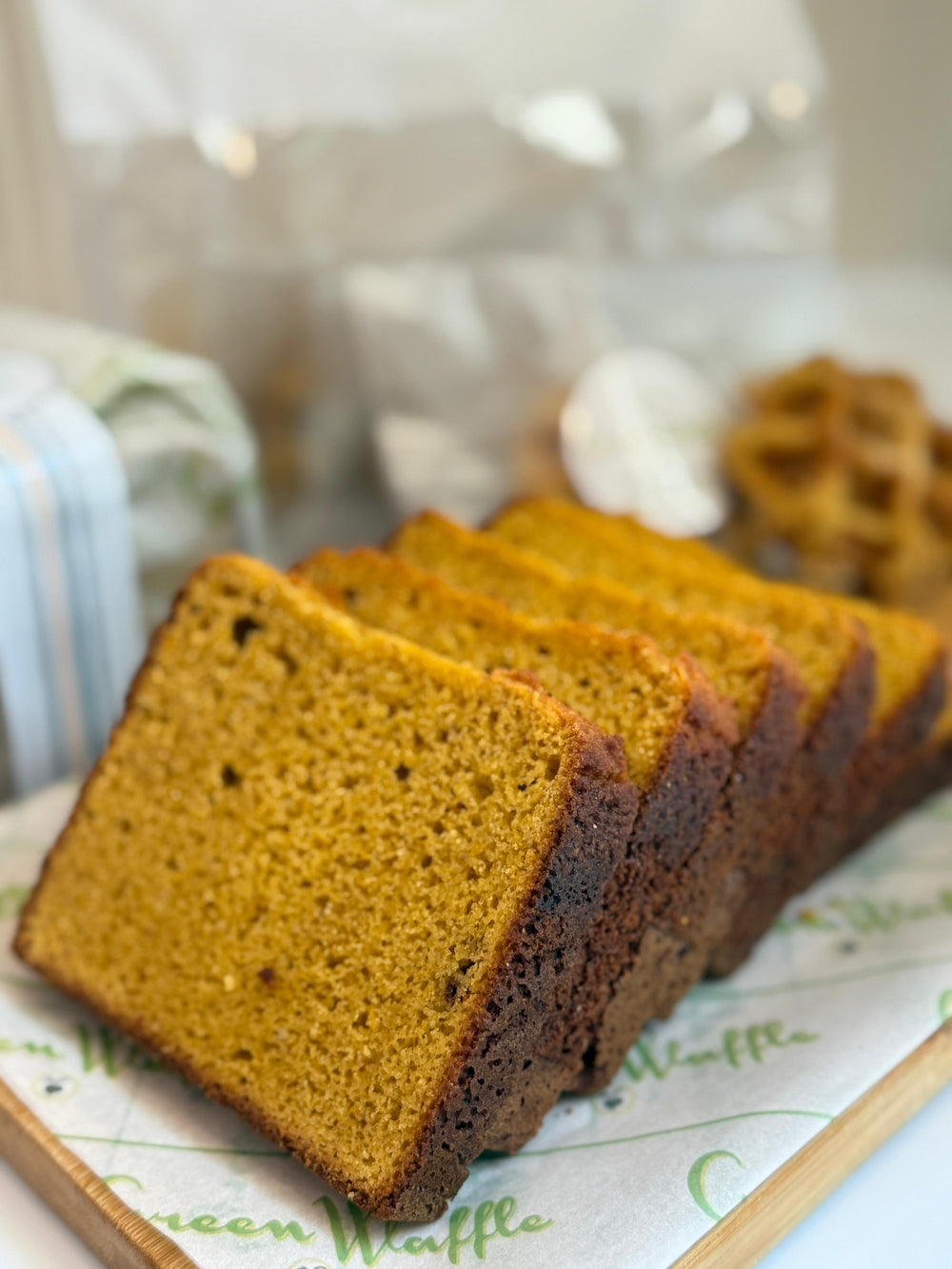 Slices of grain free bread on a parchment paper lined wooden chopping board with a blurred background